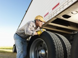 Truck driver inspects his truck.