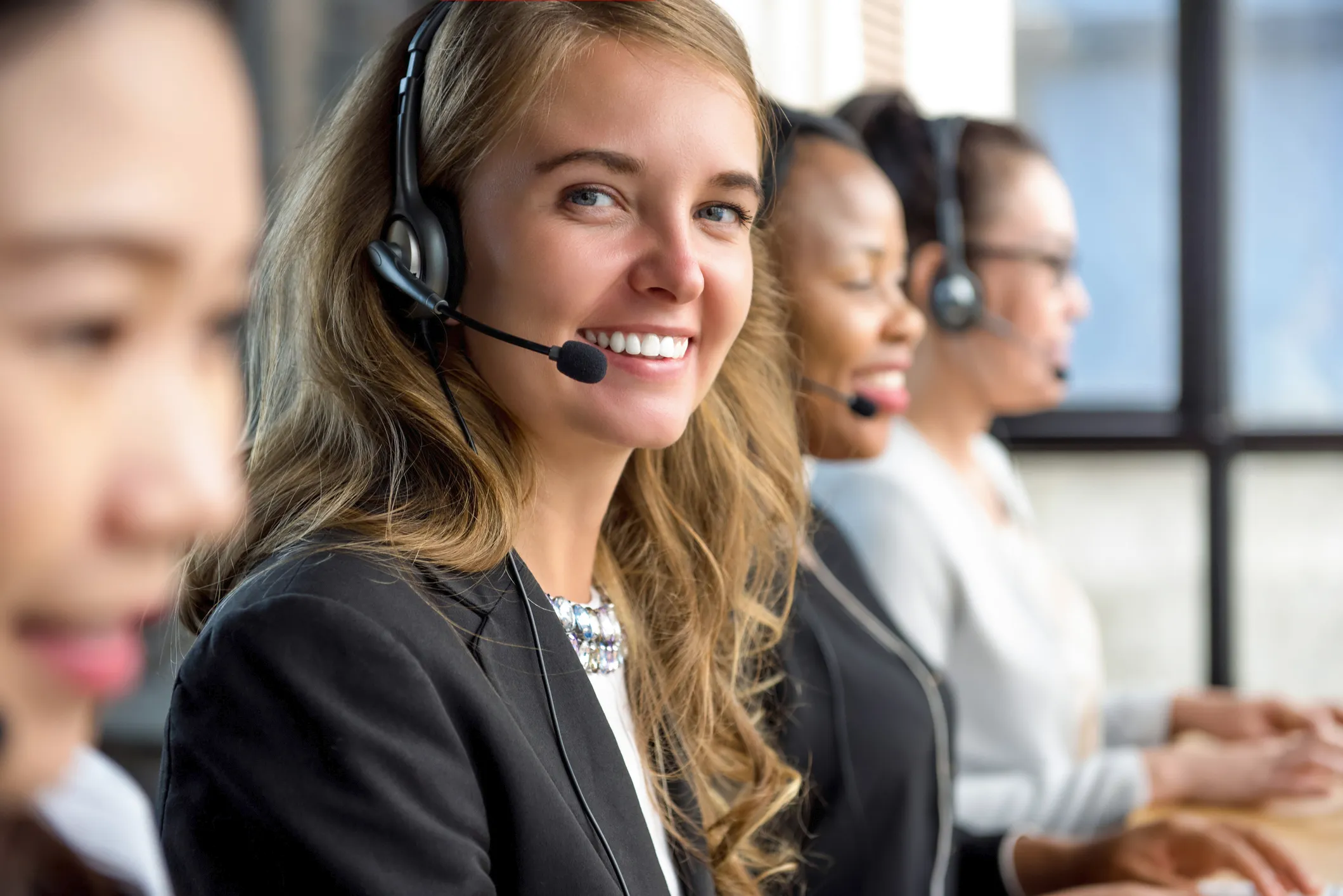 Customer support team wearing headsets in an office